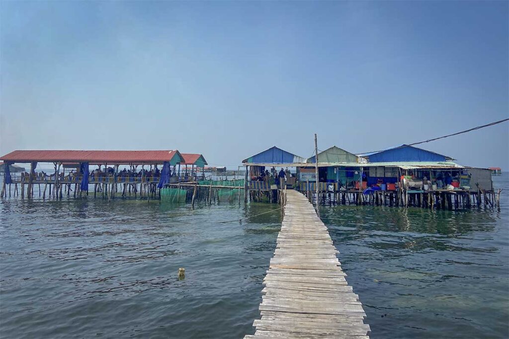 Wooden pier leading to floating seafood restaurants at Rach Vem Starfish Beach Phu Quoc