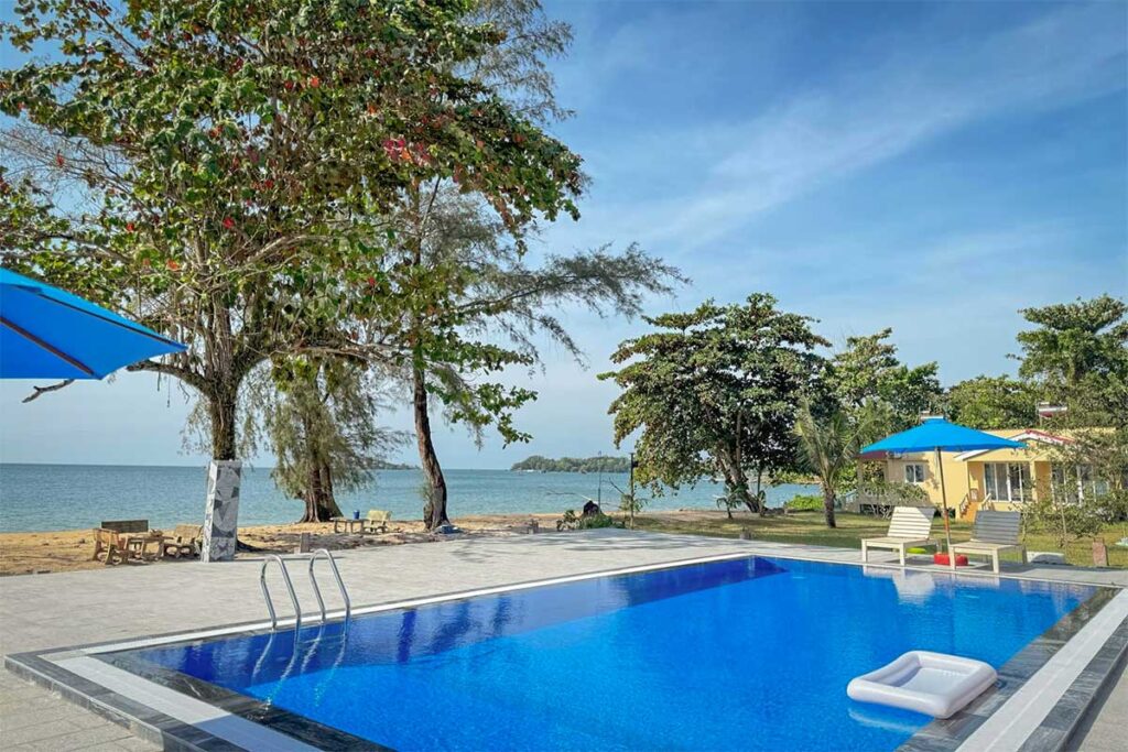 Small beachfront resort swimming pool at Vung Bau Beach Phu Quoc with sea view and tropical garden