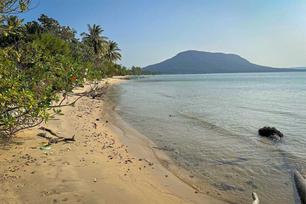 Rach Tram Beach Phu Quoc remote sandy coastline with clear water and mountain view