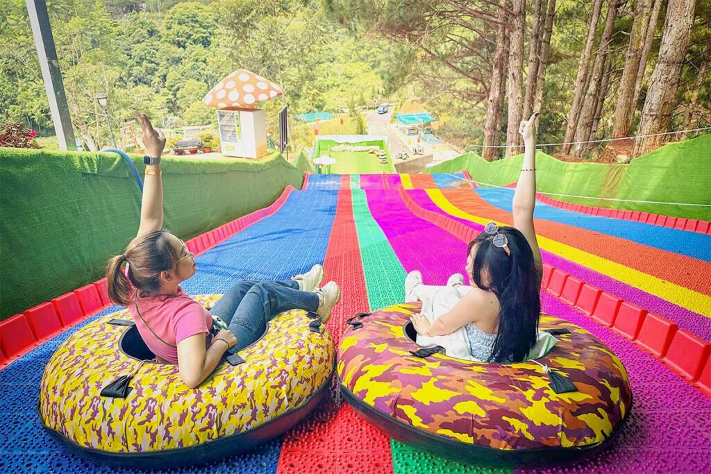 Rainbow slide at Dalat Wonderland with visitors sliding down colorful lanes in inflatable tubes