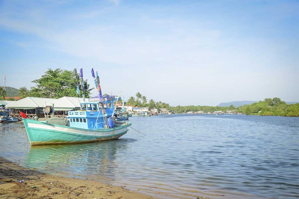 Cua Can River Phu Quoc with traditional fishing boat calm water and village houses near Cua Can Beach