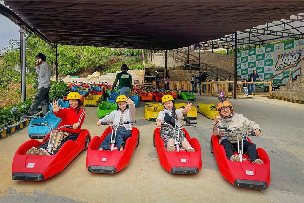 Start of the Mario Kart Dalat luge track with colorful downhill carts and helmets ready, located at Cao Nguyen Hoa on the Ta Nung route