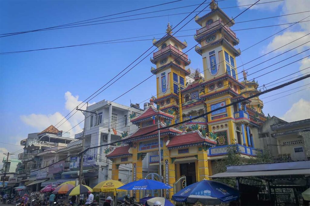 Cao Dai Temple in Phu Quoc on Nguyen Trai Street with twin towers and busy Duong Dong town street scene