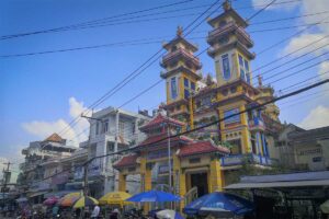 Cao Dai Temple in Phu Quoc on Nguyen Trai Street with twin towers and busy Duong Dong town street scene