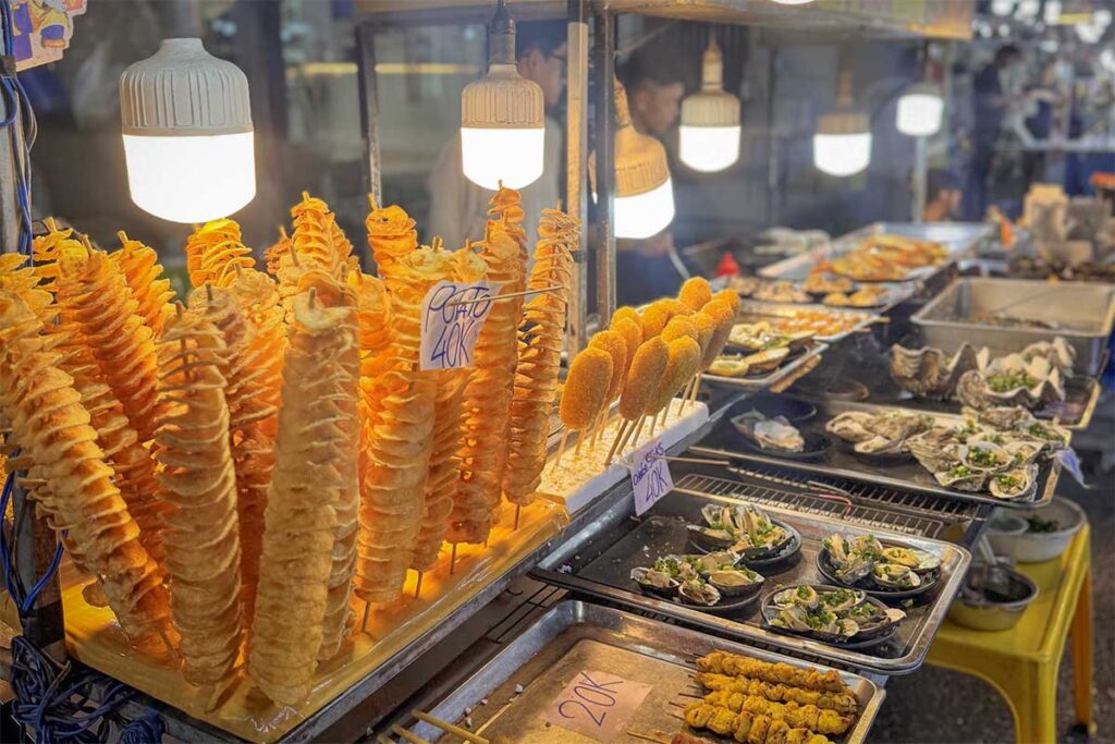 street food stall at Phu Quoc Night Market selling potato spirals oysters and grilled snacks