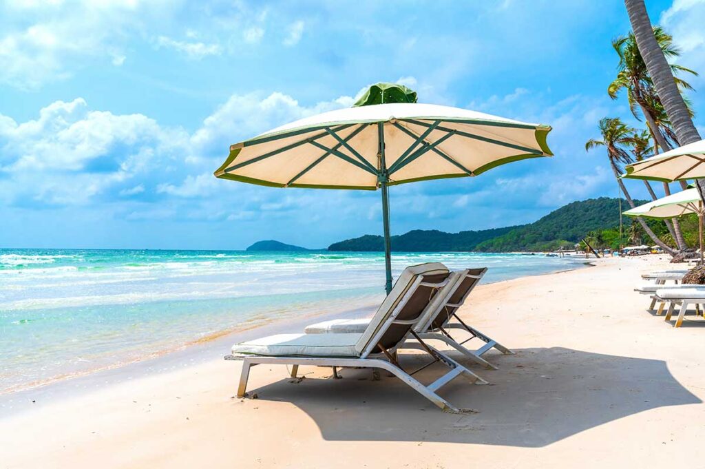 Sun loungers and umbrella on Bai Sao Beach Phu Quoc with white sand and calm blue sea