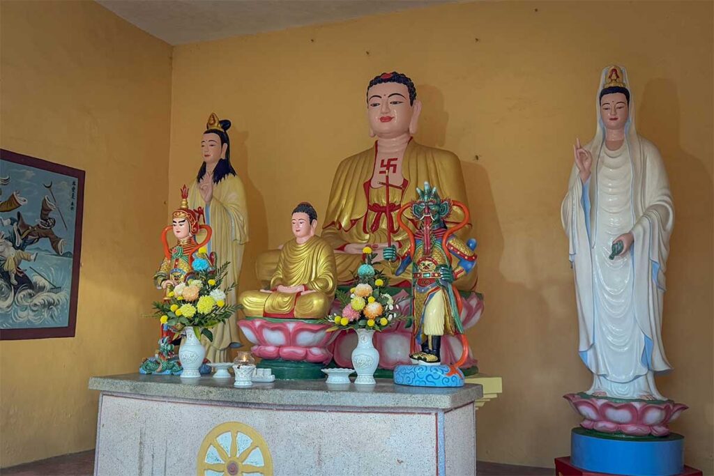 Buddhist statues inside Sung Hung Pagoda in Phu Quoc with altar offerings and prayer space