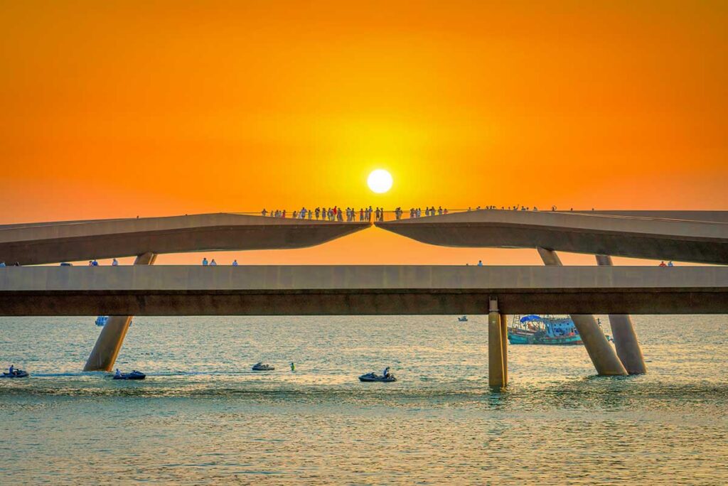 Kiss Bridge Phu Quoc with the sun perfectly aligned between the two bridge sections and visitors watching sunset