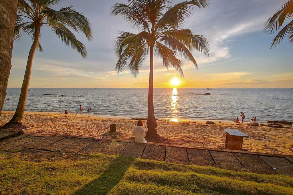 Sunset at Long Beach Bai Truong Phu Quoc with palm trees beach sand and people enjoying the evening view