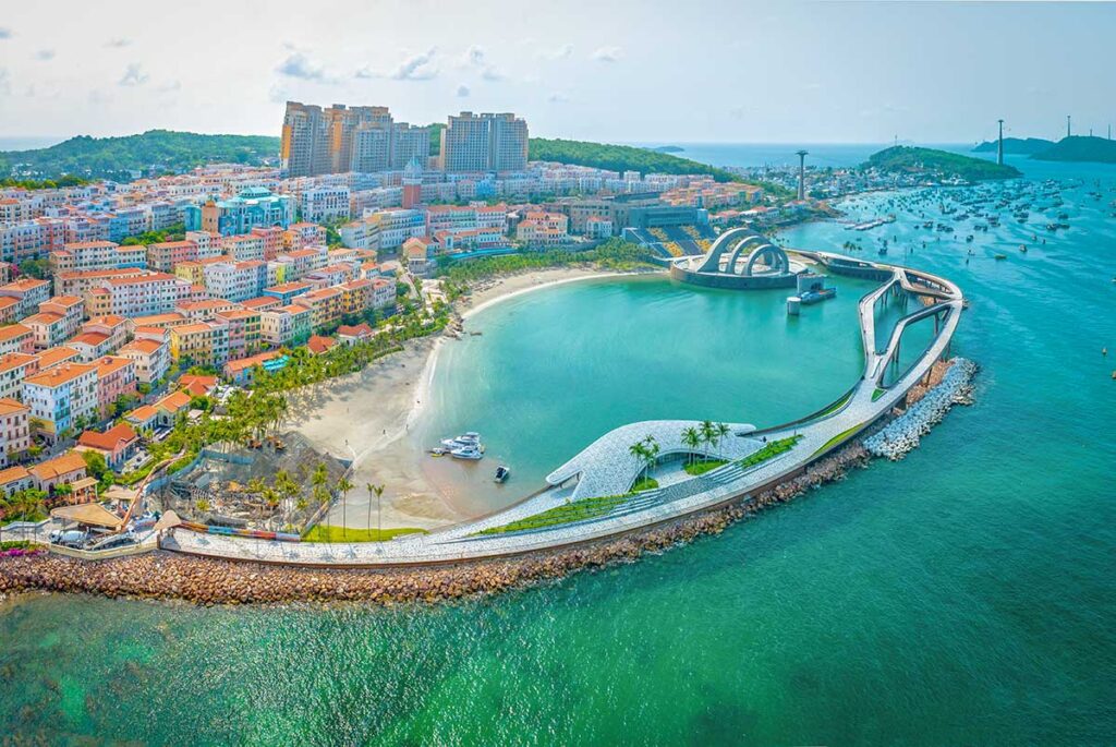 Aerial view of Sunset Town Phu Quoc with Kiss Bridge curved over the sea colorful buildings and coastline