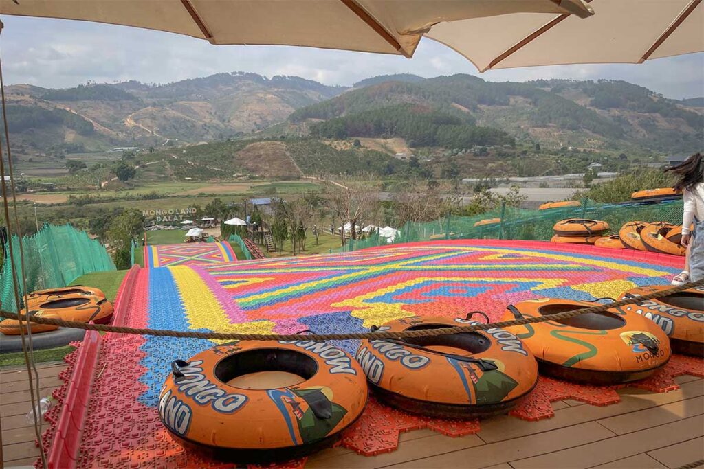 Inflatable tubes lined up at the top of the rainbow slide in Mongo Land Dalat overlooking the valley