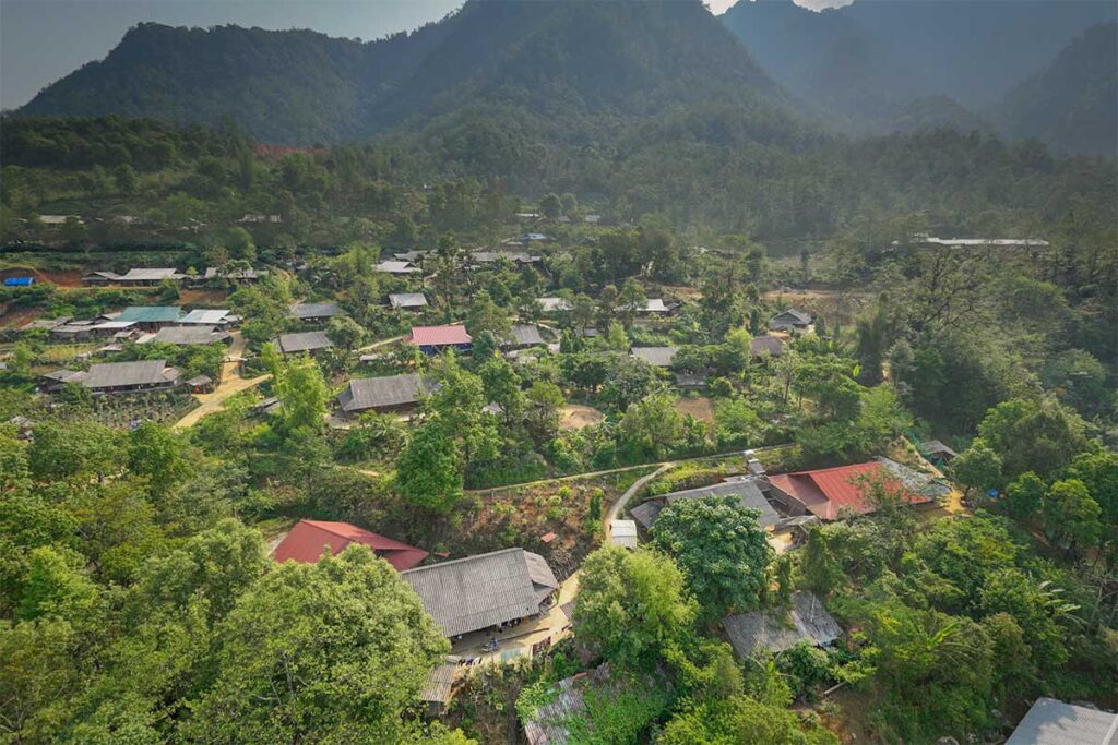 Aerial view of Sin Suoi Ho village showing scattered houses, trees, and mountain landscape in Lai Chau