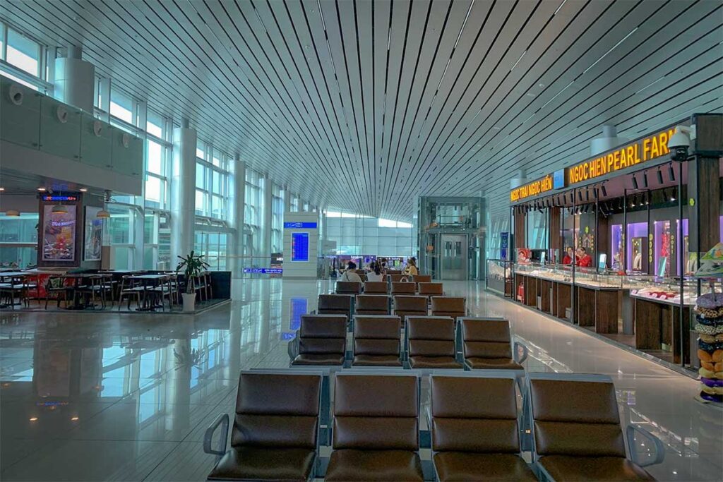 Waiting area inside Phu Quoc Airport departure hall with seats shops and passenger lounge area