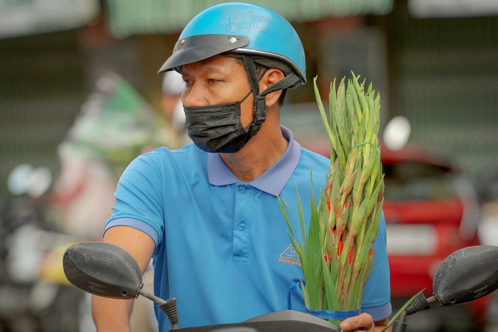 man riding a motorbike in Vietnam wearing a mask to reduce exposure to traffic pollution