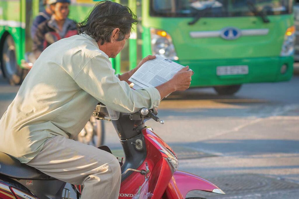 Motorbike taxi driver waiting on the street in Vietnam, typical of traditional xe ôm services that may negotiate prices directly