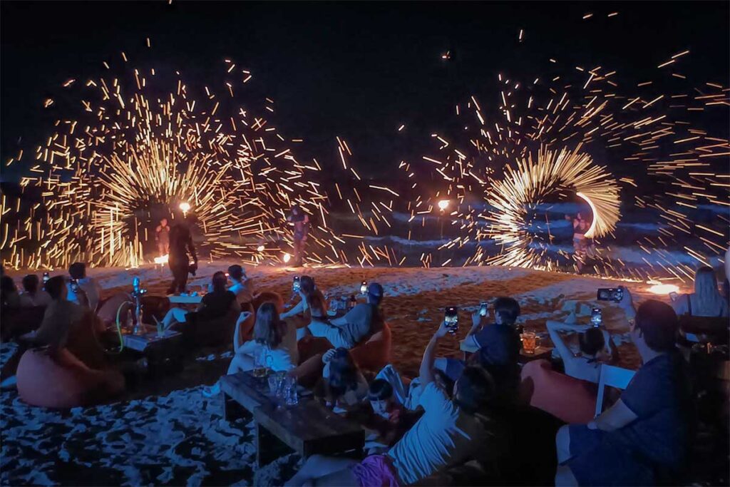Fire show at Aloha Beach Bar in Phu Quoc with sparks flying across the beach and travelers enjoying nightlife by the sea