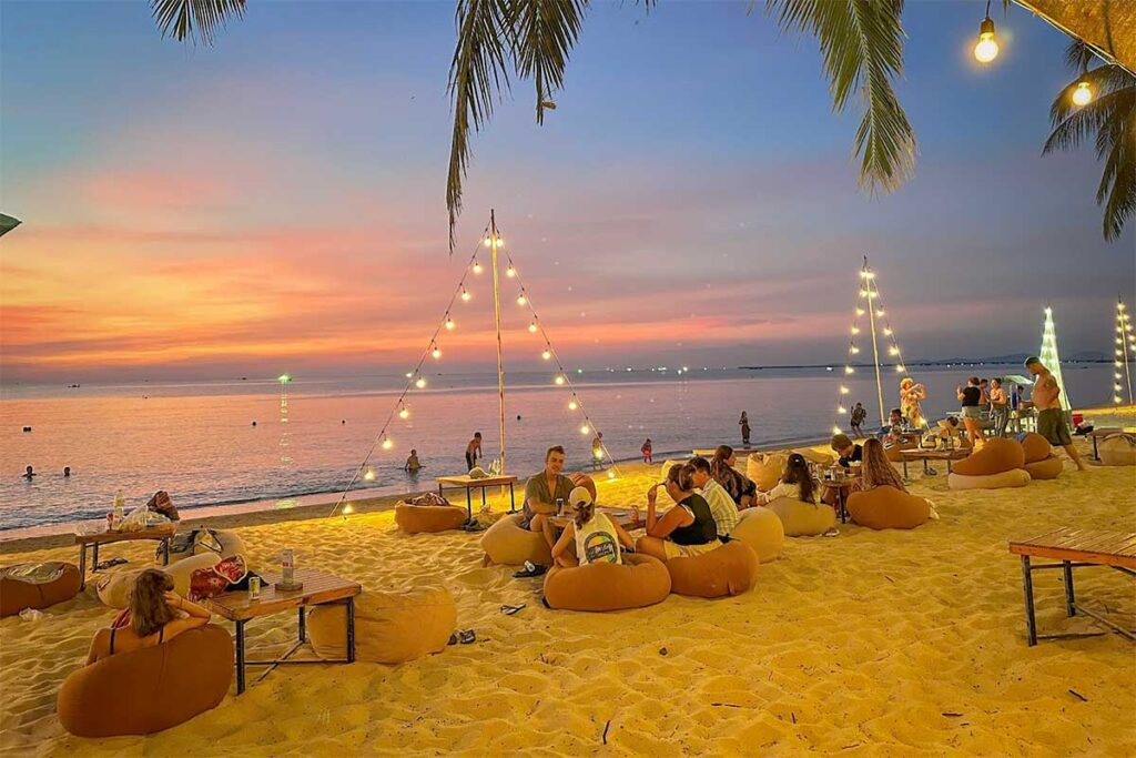 Beach nightlife at Aloha Beach Bar in Phu Quoc with bean bags on the sand, sunset views, and relaxed evening atmosphere by the sea