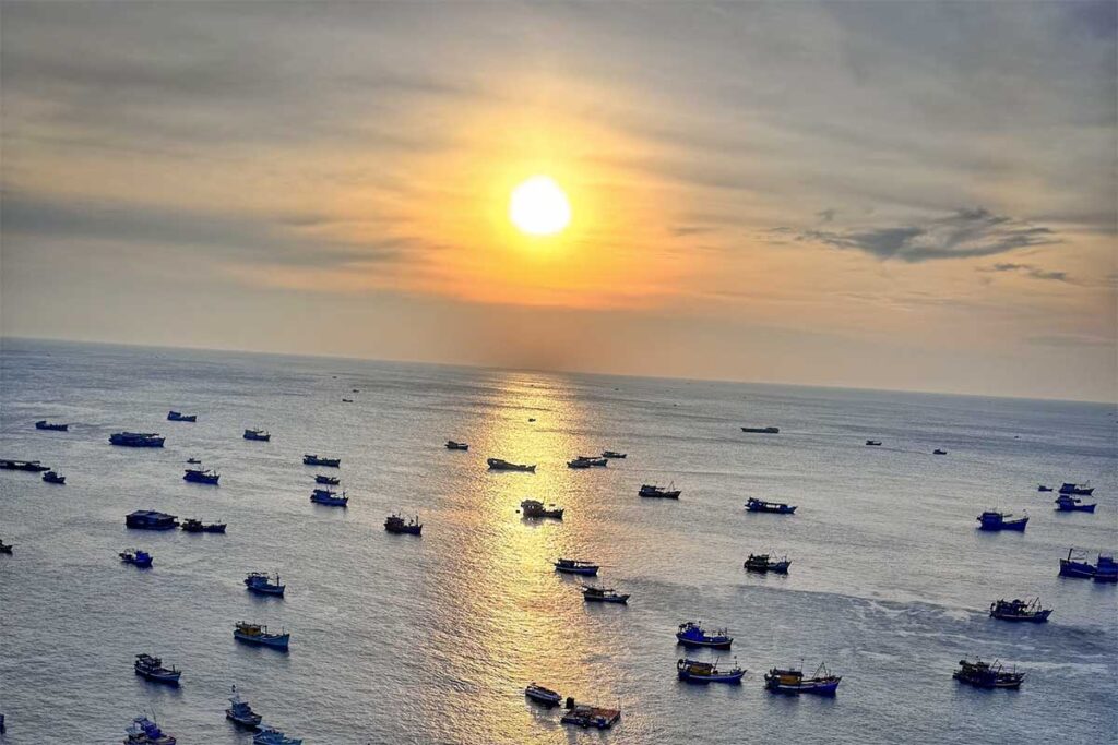 Sunrise over the An Thoi Islands in Phu Quoc with fishing boats floating on calm sea water and golden morning reflections
