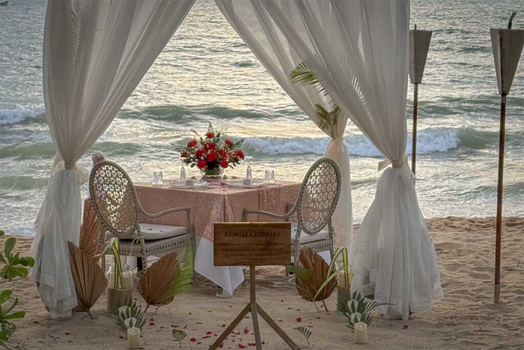 Romantic candlelight dinner setup on the beach in Phu Quoc with ocean views at sunset