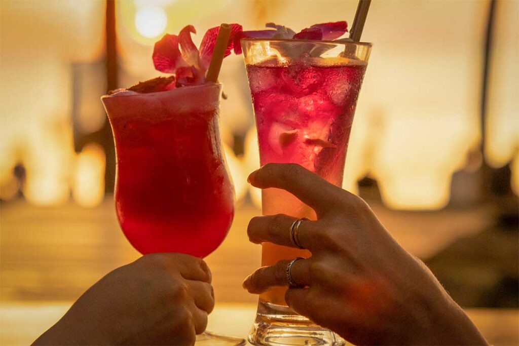 Couple holding tropical cocktails during sunset at a beach bar in Phu Quoc Vietnam
