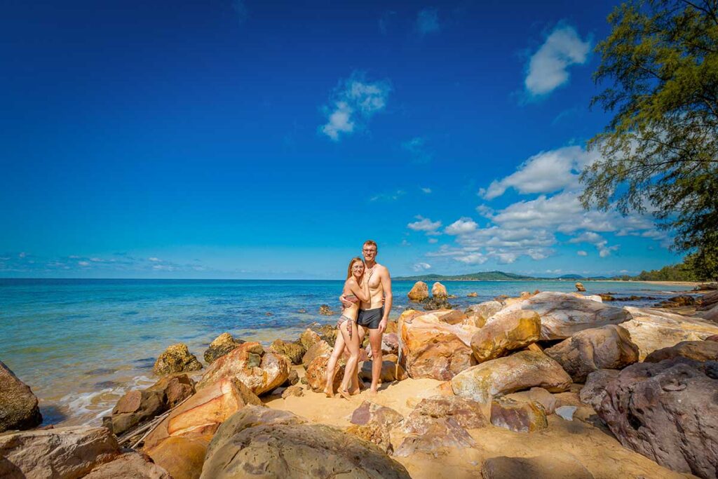 Couple enjoying a romantic beach moment among rocks and clear blue water in Phu Quoc Vietnam