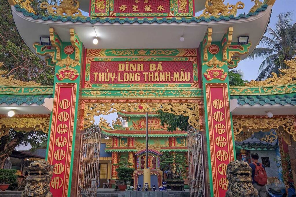 Front entrance gate of Dinh Ba Thuy Long Thanh Mau Temple in Phu Quoc with red and green architecture golden details and traditional Vietnamese design