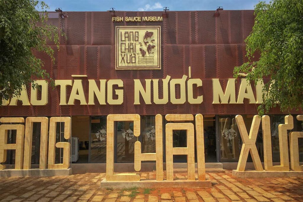 Modern exterior facade of Lang Chai Xua Fish Sauce Museum in Phan Thiet with large decorative letters and the Fish Sauce Museum sign above the entrance