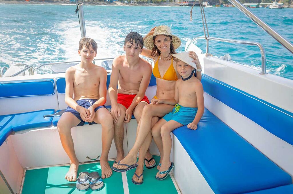 Family with children and teens enjoying a boat trip in Phu Quoc during a beach holiday in Vietnam