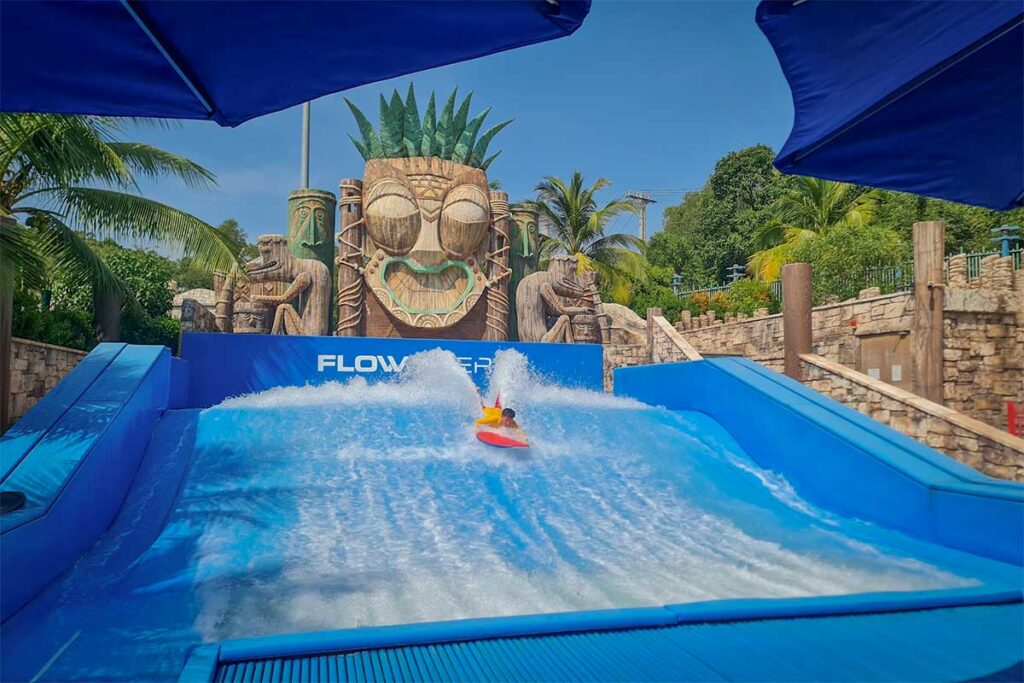 Aquatopia Water Park Phu Quoc FlowRider surfing attraction with visitor riding artificial wave in tropical setting