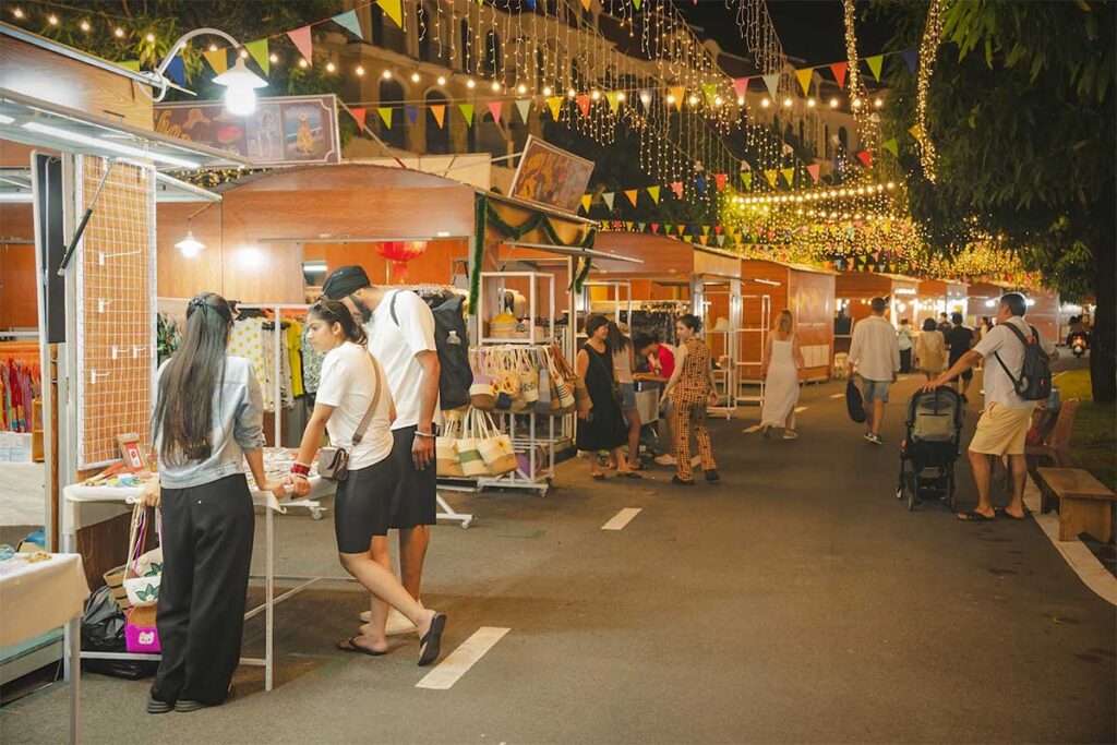 Tourists shopping and walking through the Grand World Phu Quoc night market decorated with evening lights