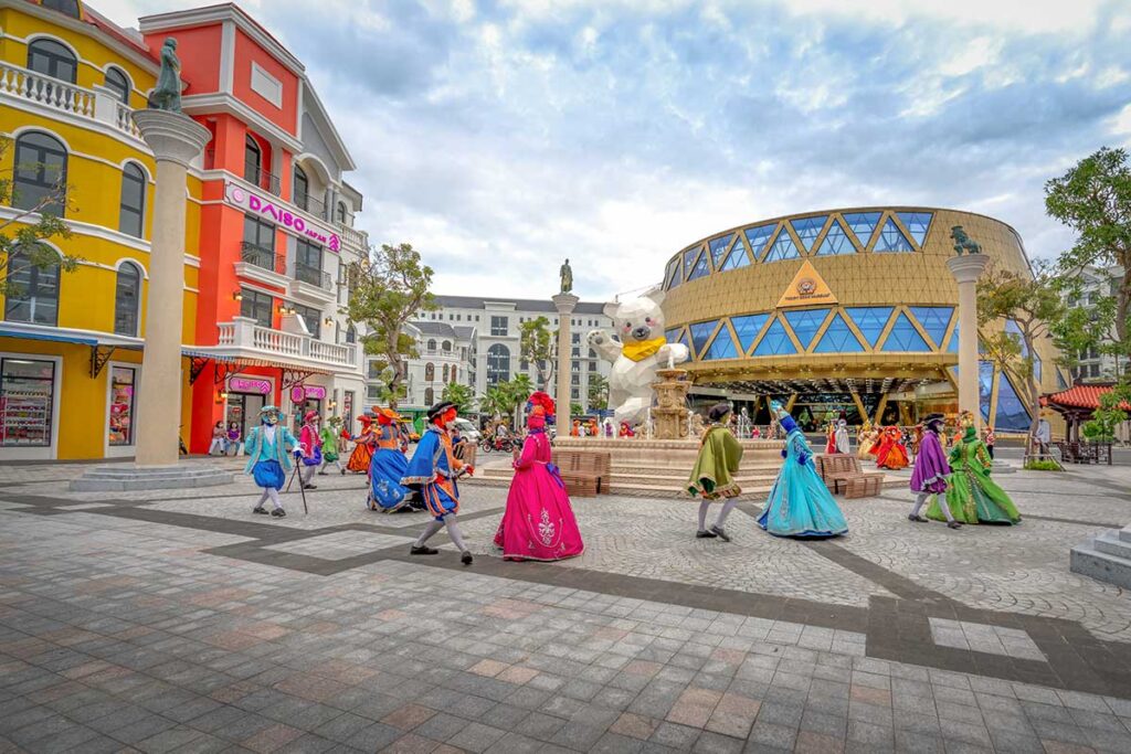 Street performers in colorful costumes performing near the Teddy Bear Museum at Grand World Phu Quoc in Vietnam