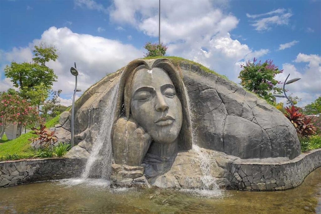 Large stone face sculpture with flowing water at Urban Park in Grand World Phu Quoc