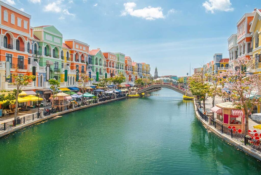 Venice style canal at Grand World Phu Quoc with colorful European inspired buildings and cafes during daytime