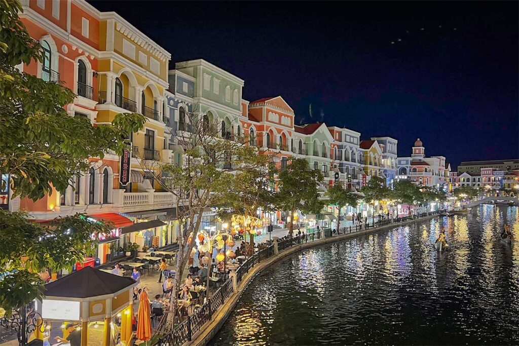 Evening view of the Venice River at Grand World Phu Quoc with colorful buildings and lights reflecting on the canal