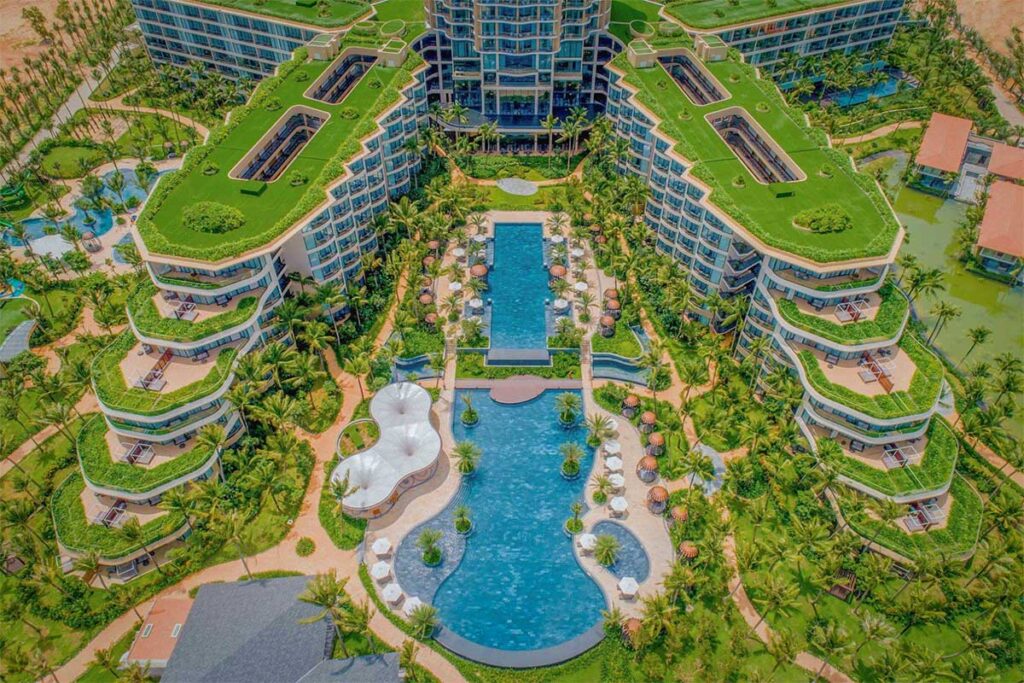 Aerial view of the luxury pool area at InterContinental Phu Quoc Long Beach Resort with tropical gardens and modern beachfront resort buildings in Phu Quoc Vietnam