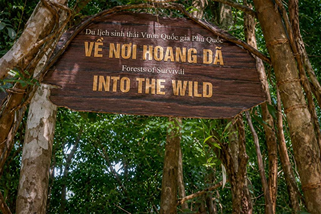 Wooden entrance sign for the Into the Wild conservation trail in Phu Quoc National Park, marking the start of a self-guided hiking route through the jungle