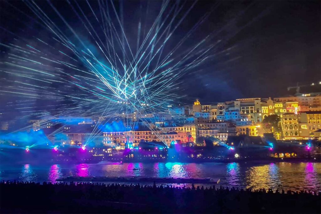 Symphony of the Sea Phu Quoc laser light show with beams spreading across the sky above the waterfront buildings and sea