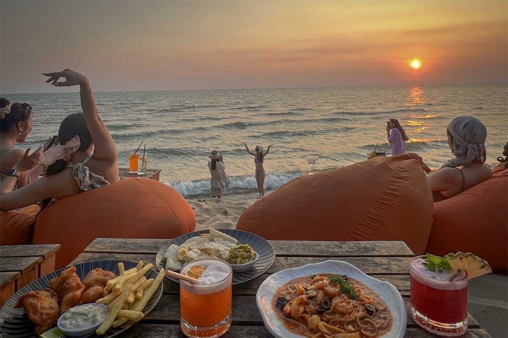 People relaxing at a beach bar on Long Beach in Phu Quoc while enjoying sunset drinks and ocean views
