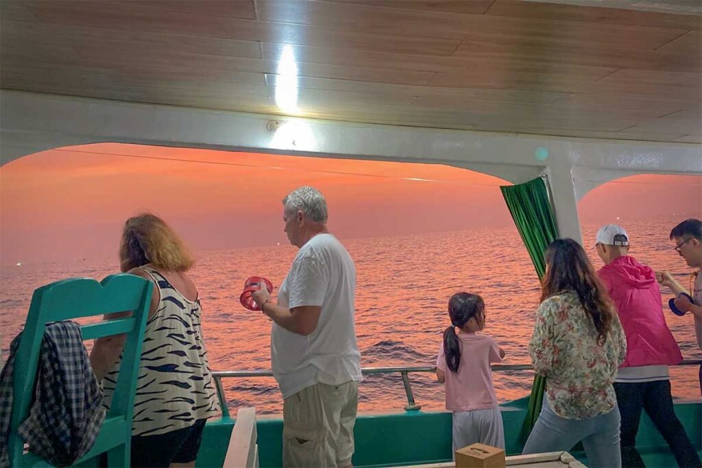 Travelers on a night squid fishing boat tour in Phu Quoc during sunset with sea views and evening activity on the water