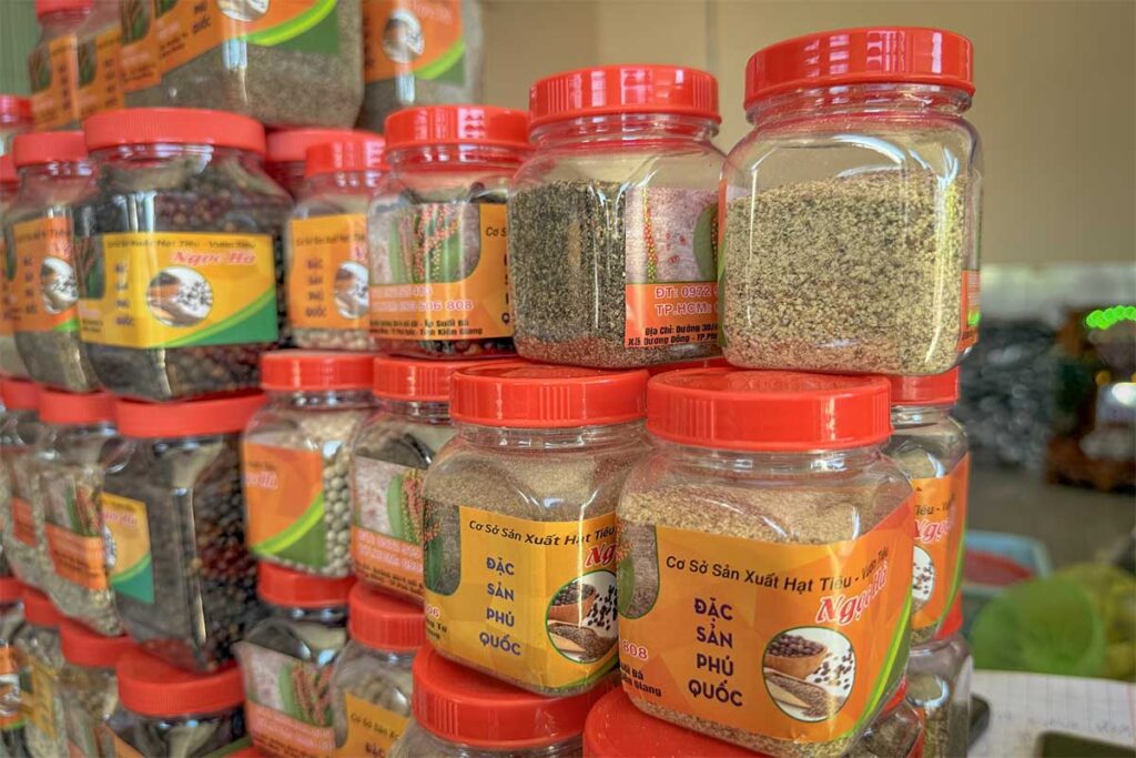 Jars of ground and whole Phu Quoc pepper displayed in a local souvenir shop with different spice varieties