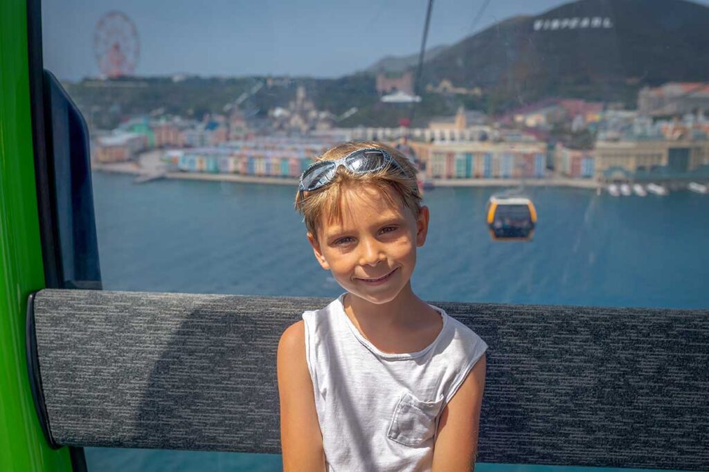 Young boy riding the Phu Quoc Cable Car above Sunset Town and Hon Thom Island during a family holiday in Vietnam
