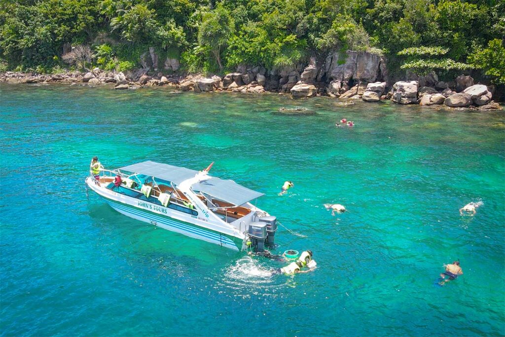Speedboat snorkeling tour in Phu Quoc with travelers exploring coral reefs in the clear water near tropical islands