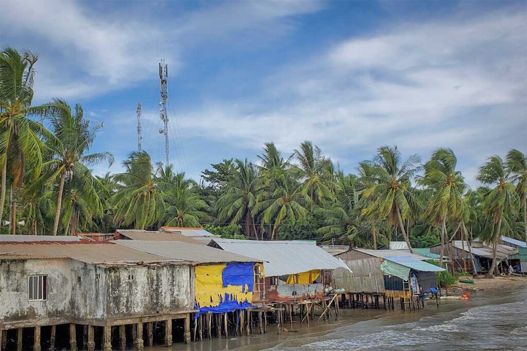 Simple stilt houses along the shoreline of Rach Tram Fishing Village in northern Phu Quoc surrounded by coconut trees