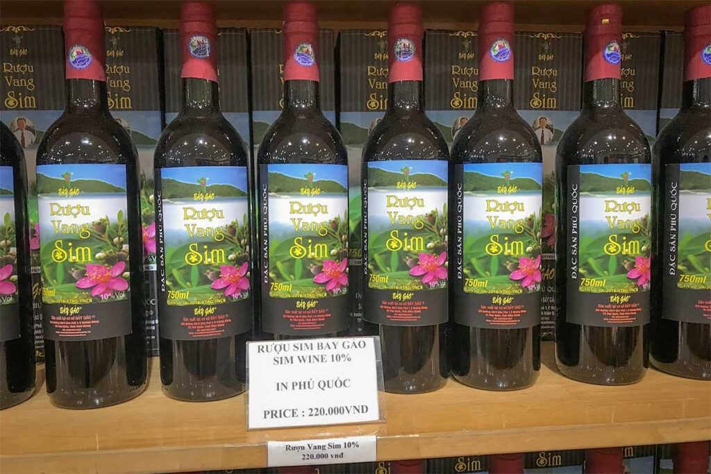 Bottles of traditional sim wine displayed in a specialty shop in Phu Quoc with local rose myrtle wine labels and souvenir packaging