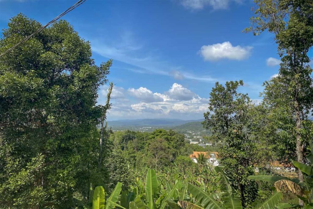 View over Phu Quoc island from Su Muon Pagoda with trees valley and distant hills under blue sky