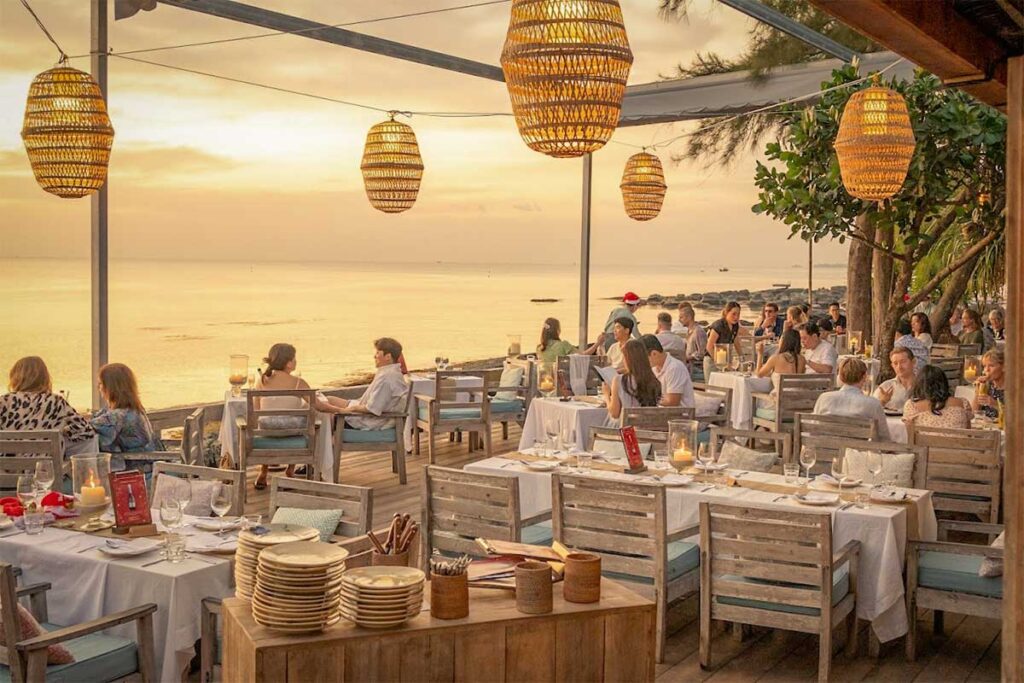 Sunset dinner at On The Rock restaurant in Phu Quoc with oceanfront tables, candlelight atmosphere, and sea views at dusk