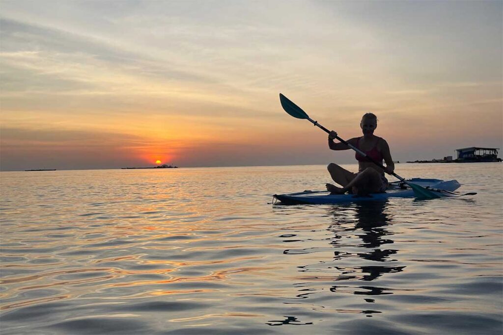 Woman kayaking on calm sea water during sunset in Phu Quoc Vietnam