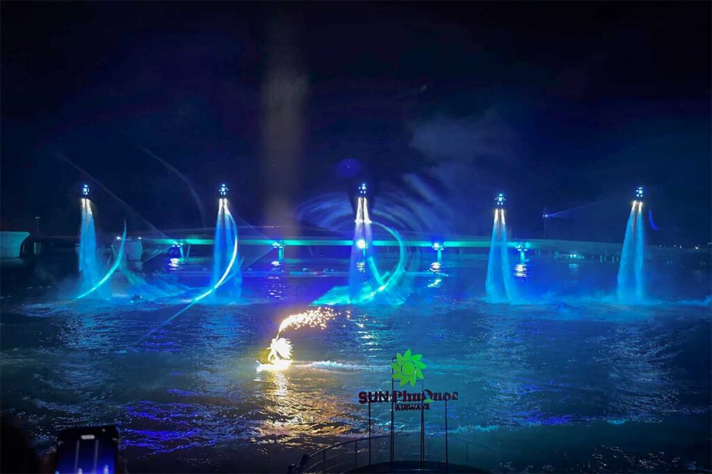 Symphony of the Sea Phu Quoc show with multiple flyboard performers creating blue light trails above the water and jetski action below at night