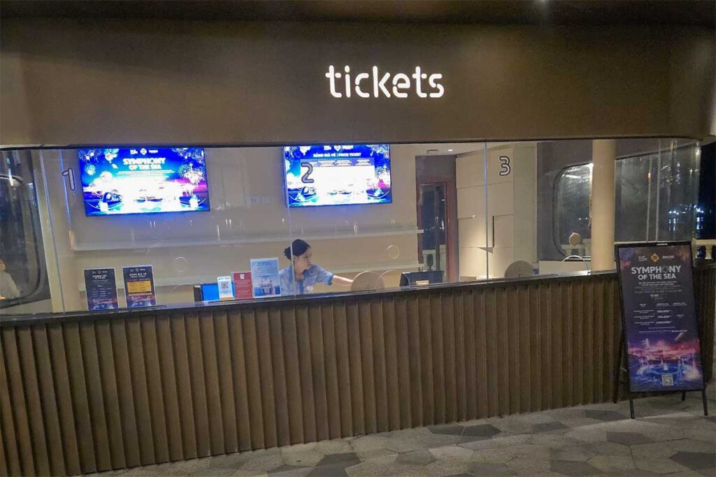 Symphony of the Sea ticket counter in Sunset Town Phu Quoc with staff behind the desk and screens displaying show information for visitors buying tickets