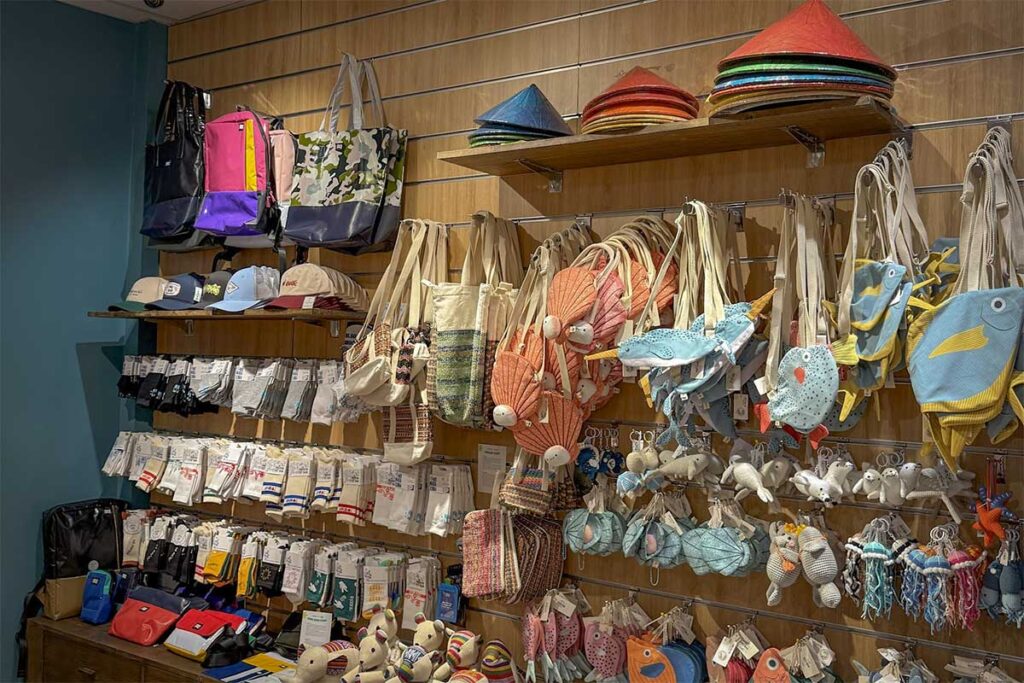Beach bags hats stuffed toys and handmade accessories displayed inside a souvenir shop in Phu Quoc with colorful travel and beach items for tourists